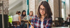 a girl holding the pen in the class room
