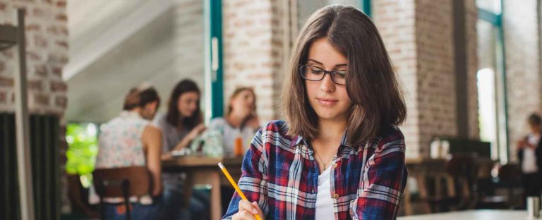 a girl holding the pen in the class room