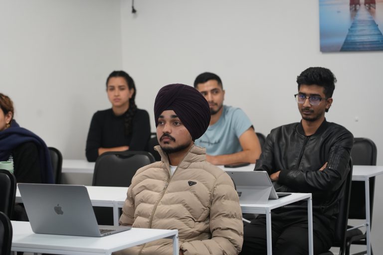 A indian student is sitting on the chair in the class