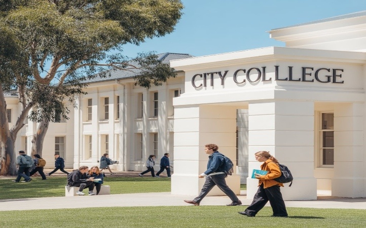 Students walking on campus near City College building on a sunny day